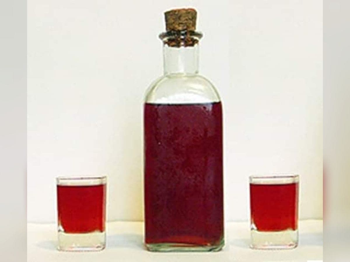 Botella y copa de chinguirito, el licor oscuro de papelón y aguardiente