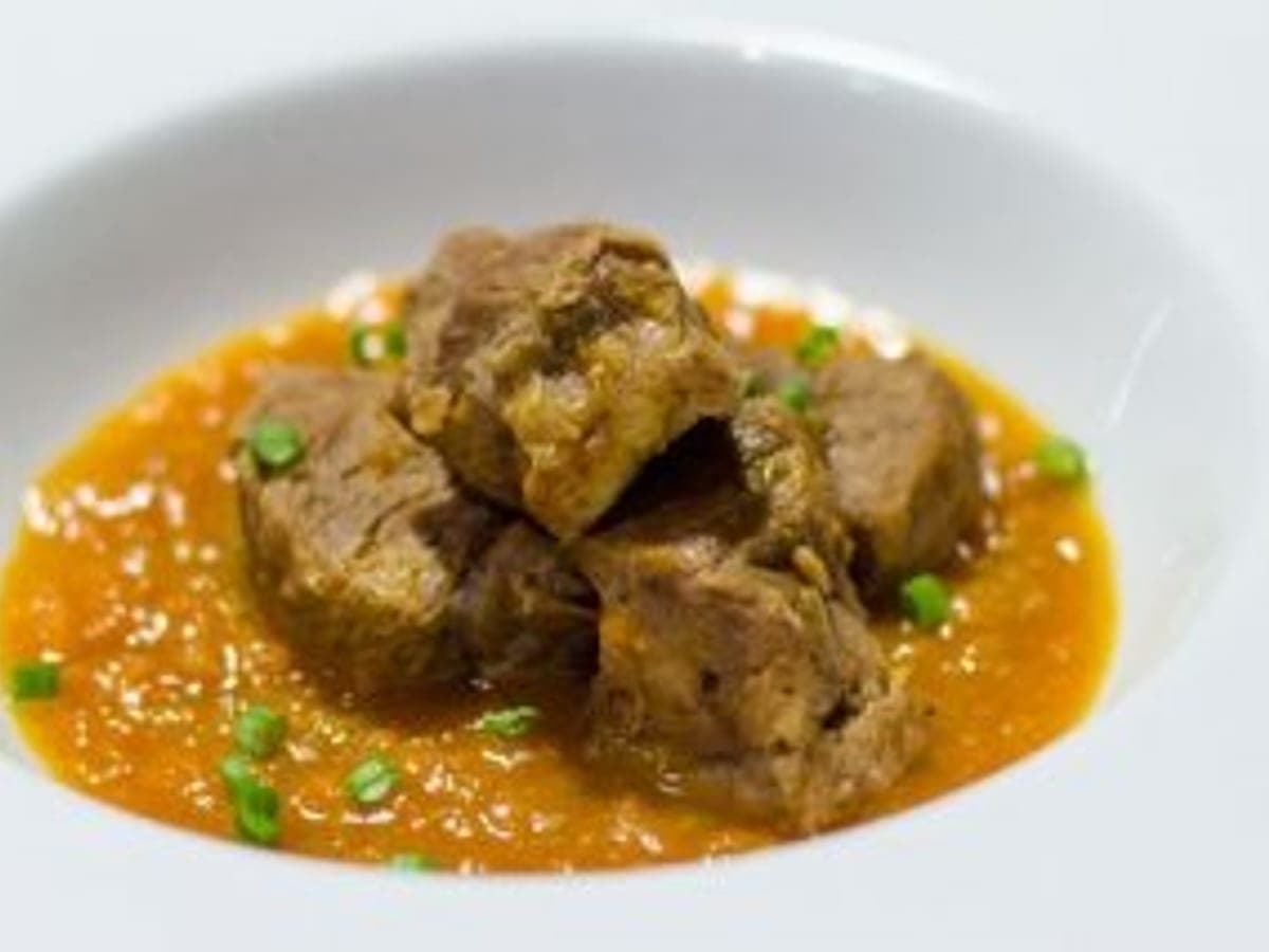 Guiso de corazón de res en salsa espesa de leche de coco servido en un plato hondo
