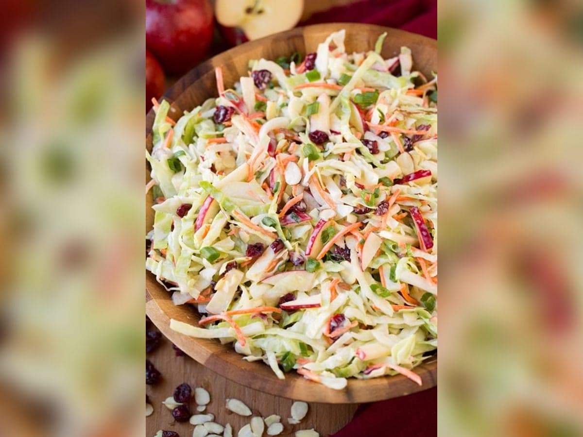 Ensalada rallada de repollo y zanahoria con aderezo cremoso y pasas