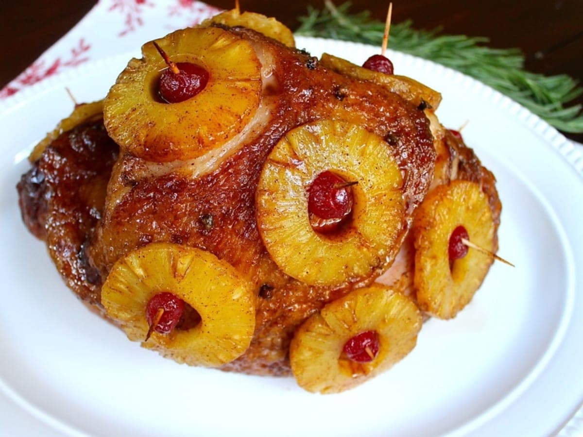 Jamón planchado glaseado y adornado con ruedas de piña sujetas con palillos