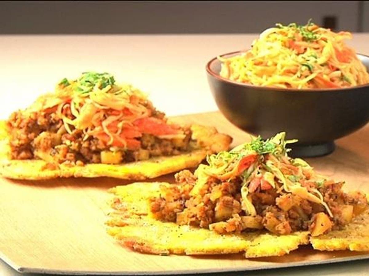 Patacón relleno zuliano abierto, mostrando el relleno de queso y vegetales entre dos tapas de plátano verde frito