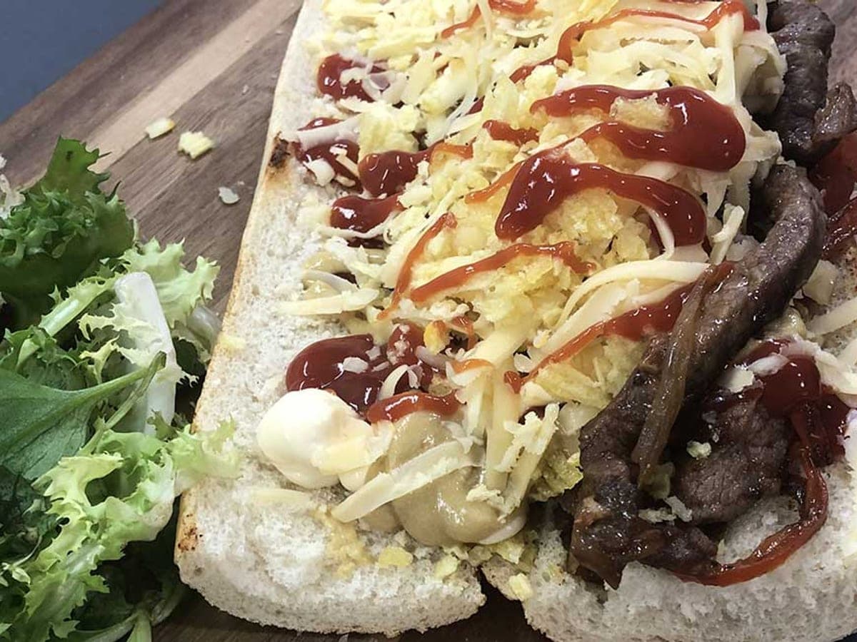 Pepito venezolano abierto, relleno de carne, lechuga, papas fritas y salsas