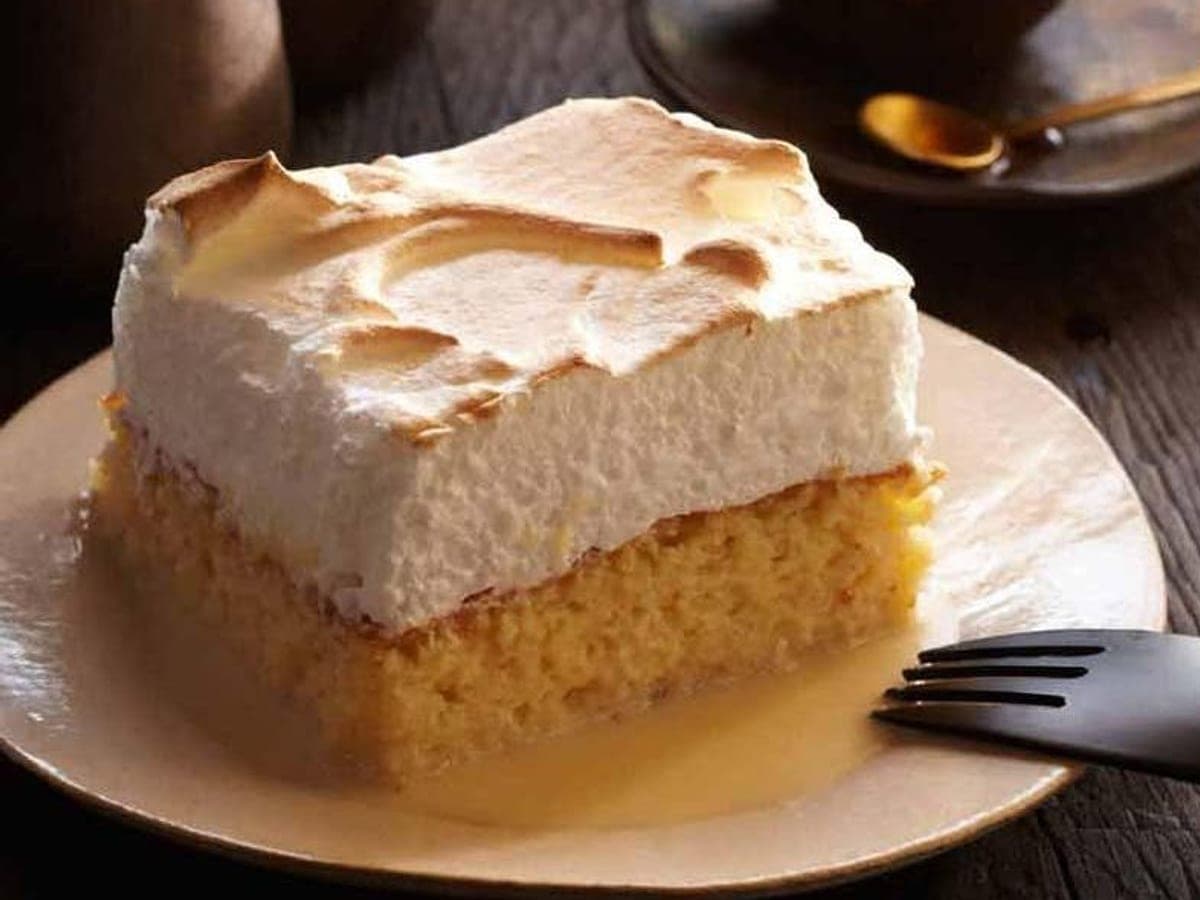Porción de torta de tres leches cubierta de merengue italiano dorado