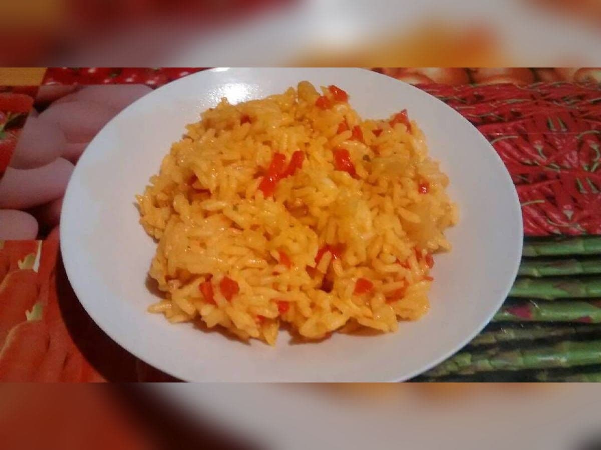 Arroz aliñado venezolano coloreado con onoto, con cebolla y ají dulce, decorado con perejil