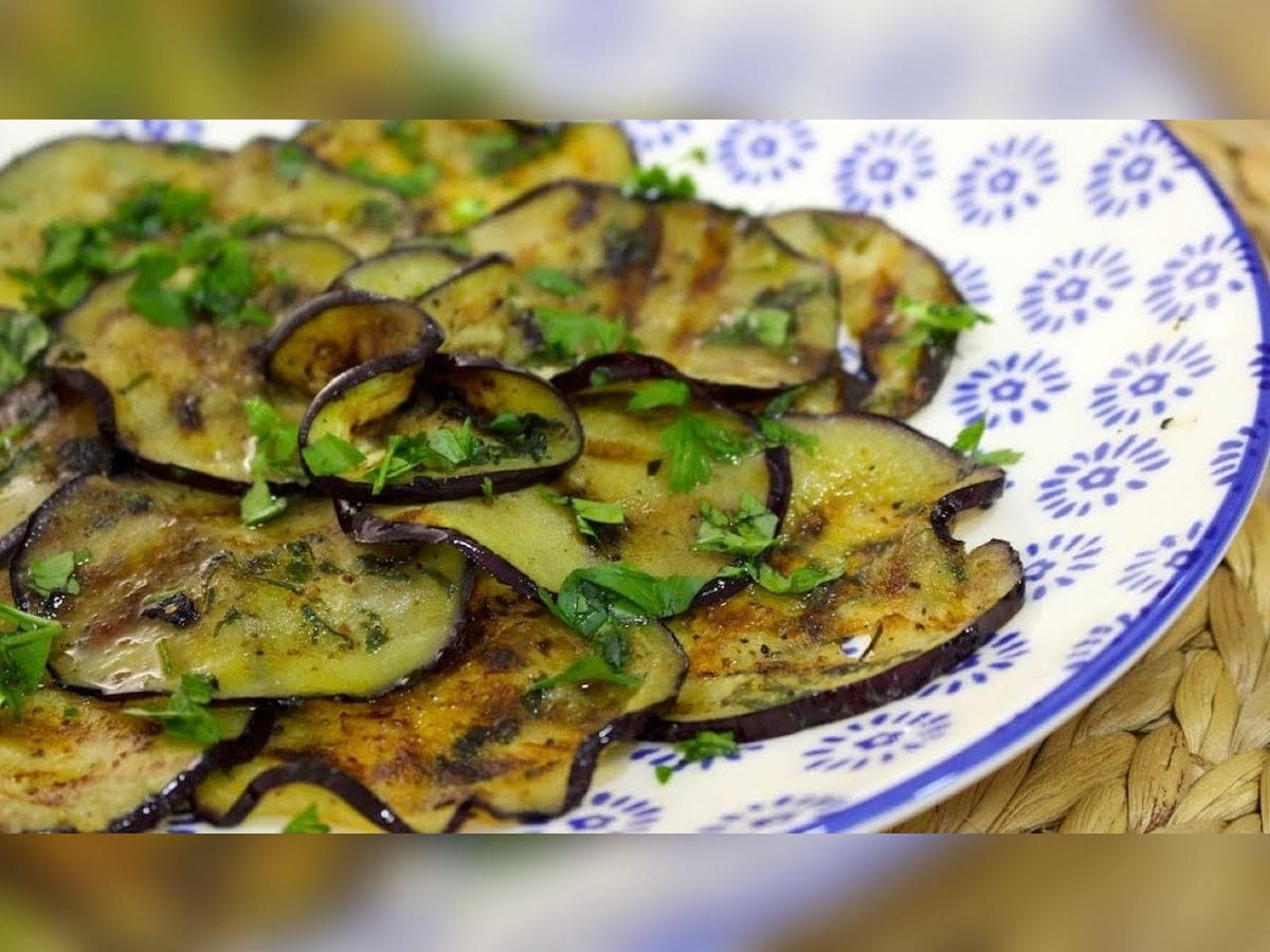 Rodajas de berenjena asada bañadas en ajo, perejil y aceite de oliva