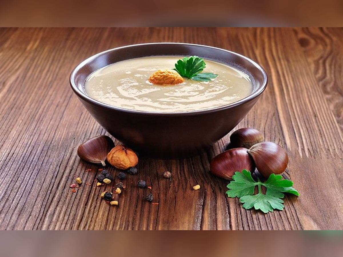 Plato hondo con crema de castañas espesa, decorada con castañas enteras