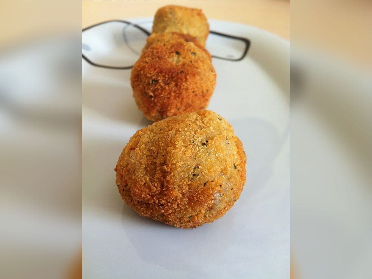 Croquetas de hallaca fritas y doradas, escurridas sobre papel absorbente