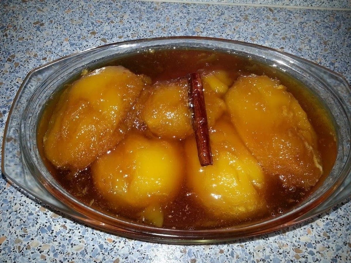 Pepas de mango en almíbar acaramelado dentro de una paila