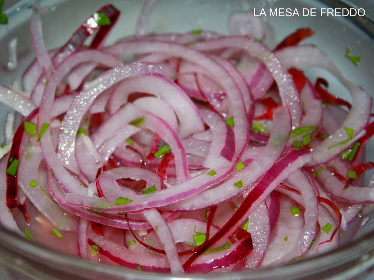 Ensalada de cebolla morada en rodajas finas con perejil picado y limón
