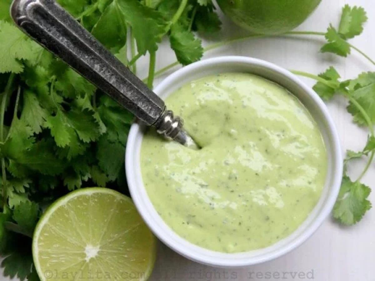 Guasacaca venezolana verde y lisa, servida en un cuenco con cilantro al lado
