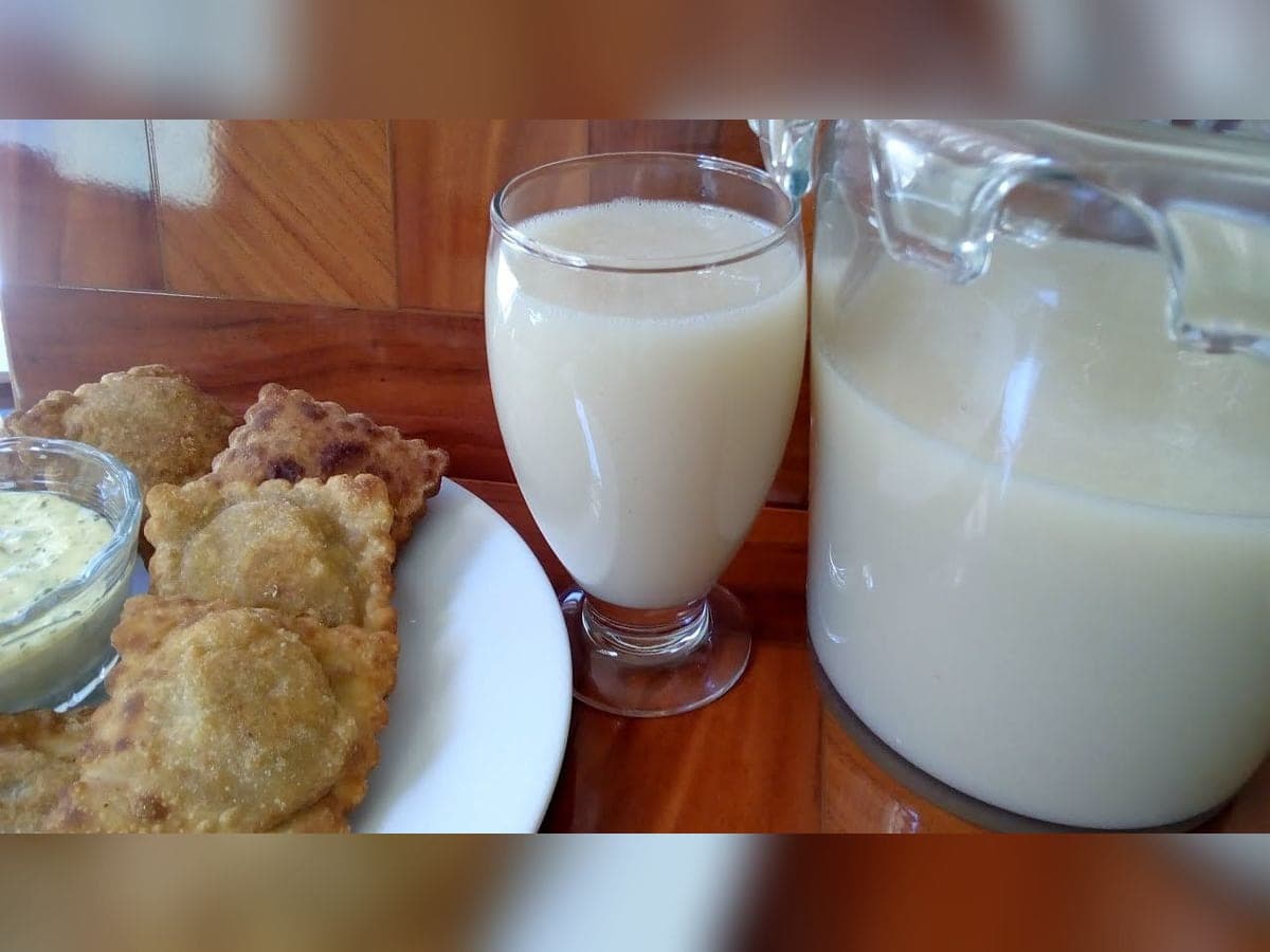 Vaso de masato de arroz tachirense adornado con una flor de geranio