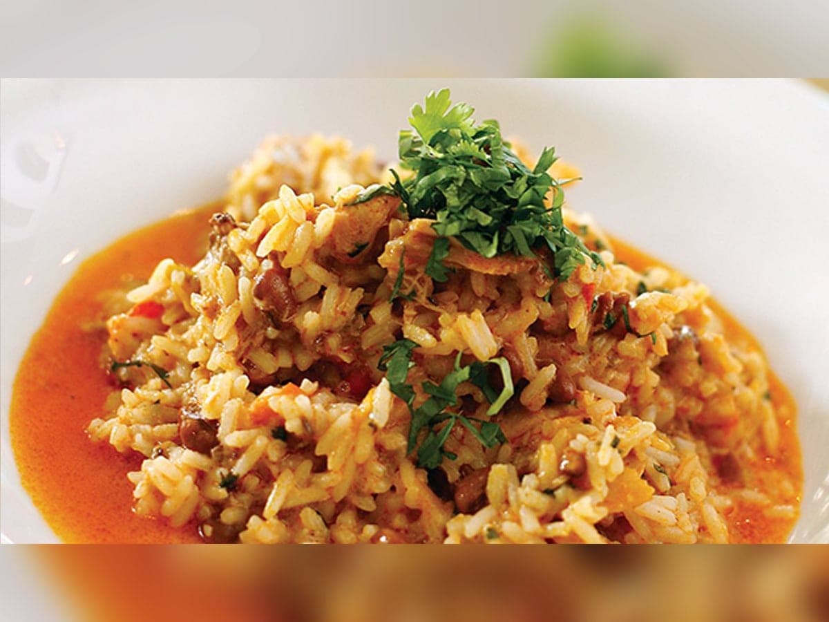 Pelao guayanés servido en plato hondo, arroz con pollo bañado en su salsa y decorado con cilantro
