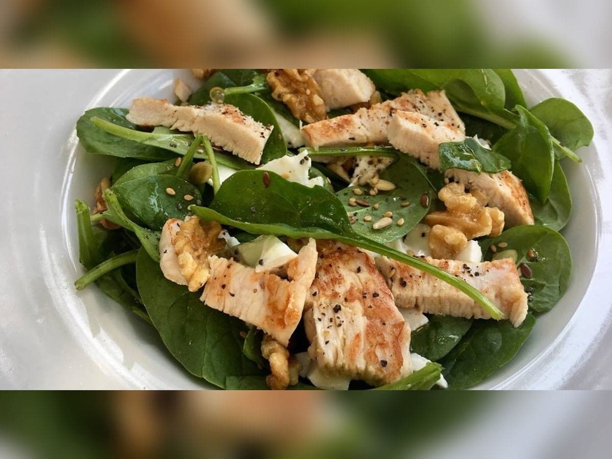 Salteado de pechuga de pollo con espinaca y cebolla roja en una sartén