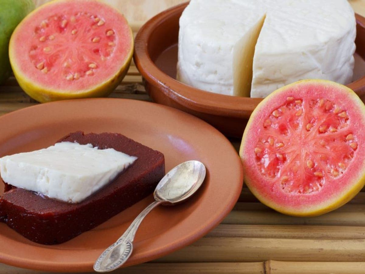 Bocadillos de guayaba cortados con una lámina de queso blanco encima, sujetos con palillos