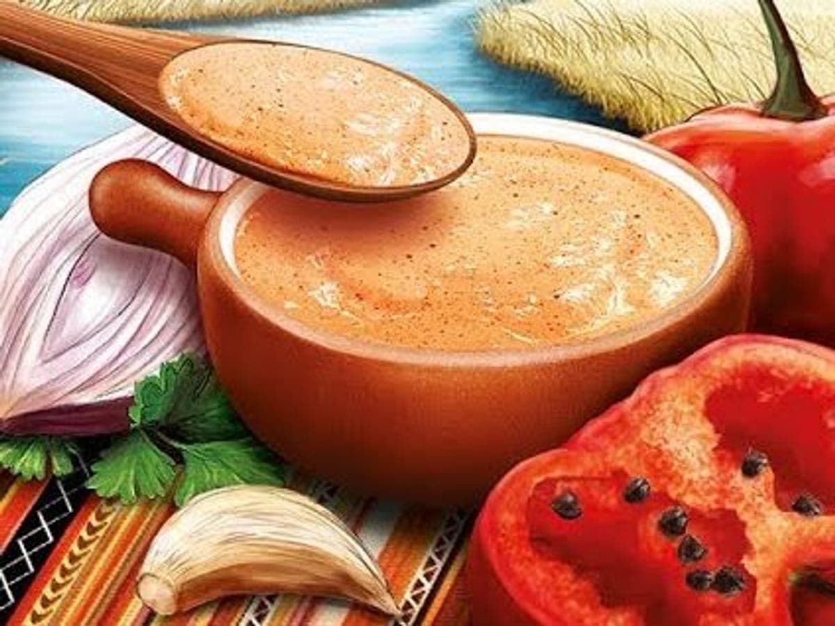 Salsa de rocoto cremosa en un cuenco, decorada con hojitas de perejil