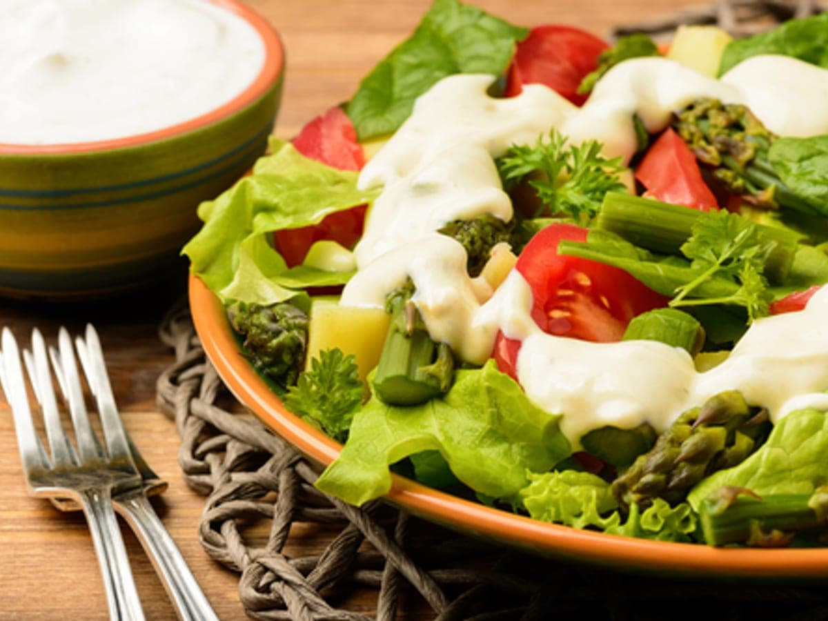 Bol pequeño con salsa de yogurt blanca y hojas de menta picadas por encima