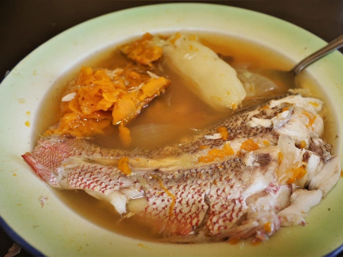 Sancocho de pargo servido en plato hondo, con una rueda de pescado, ocumo y topocho en su caldo