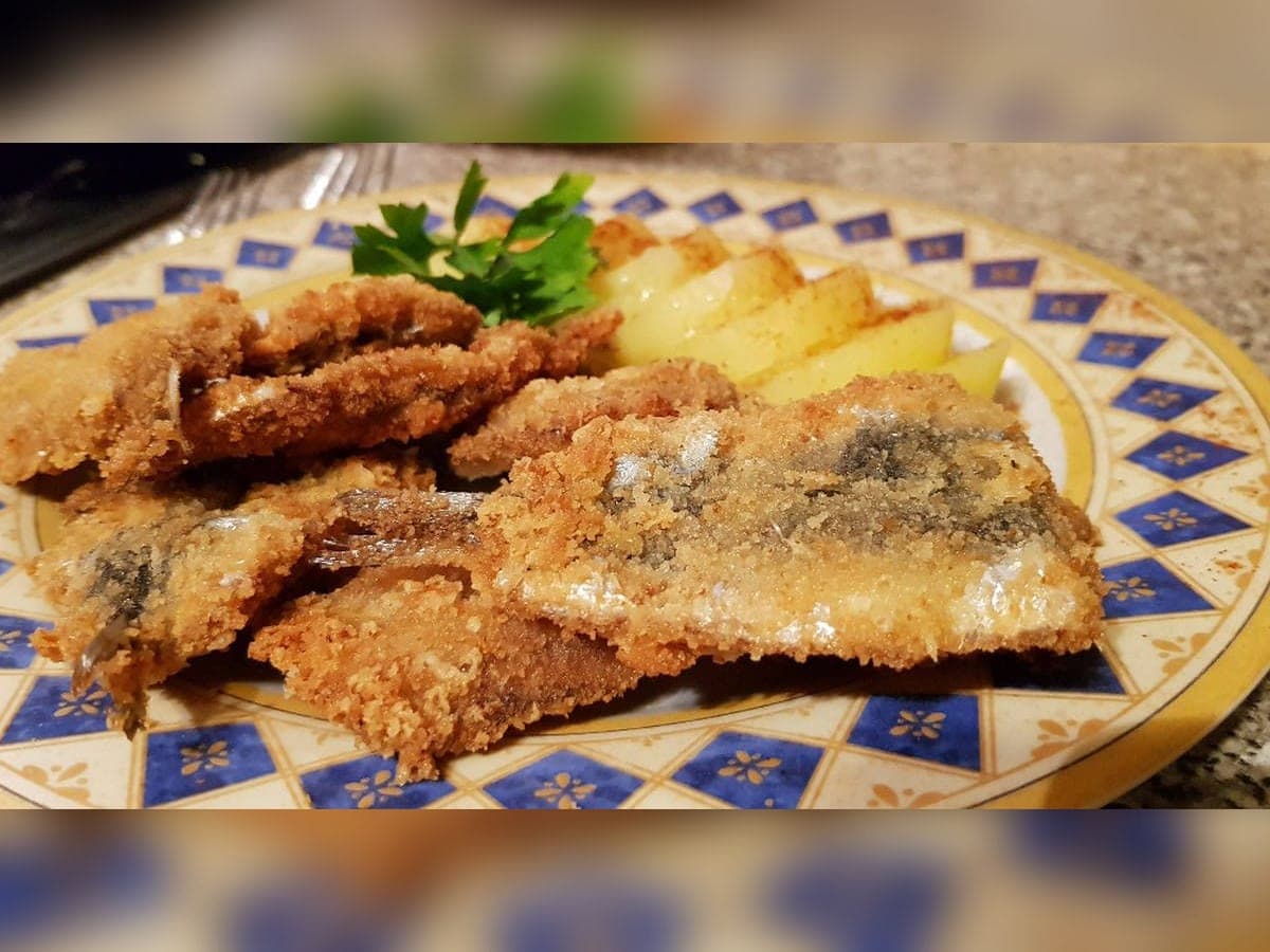 Filetes de sardina rebozados y fritos, dorados sobre papel absorbente