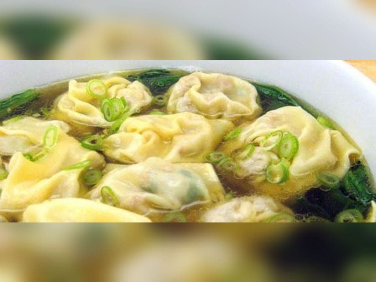Sopa de envueltos andina servida en plato de barro con cebollín picado