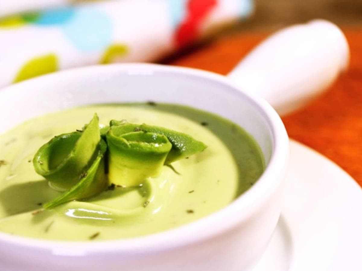 Plato hondo de sopa fría de aguacate, de color verde claro y textura cremosa