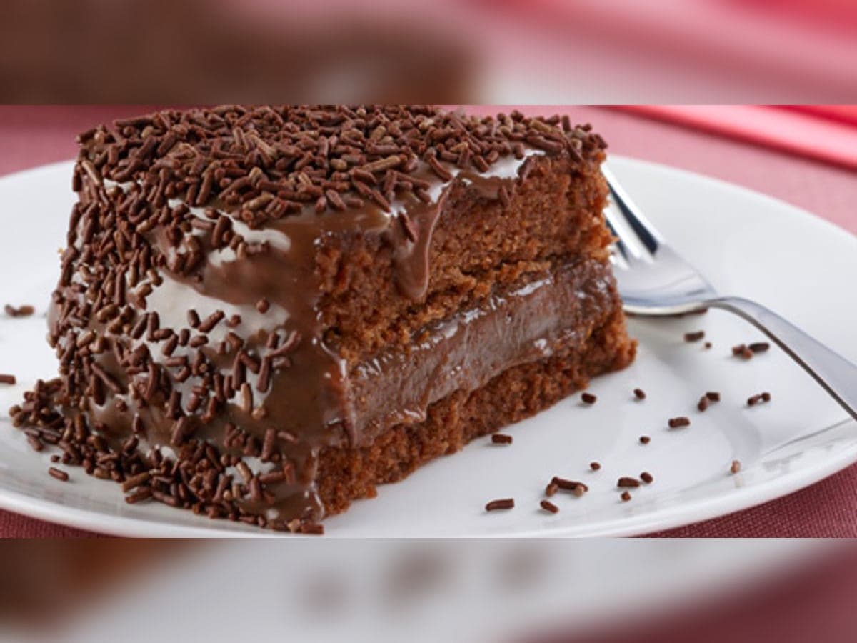 Torta de chocolate de dos capas cubierta de crema de chocolate y lluvia de chocolate