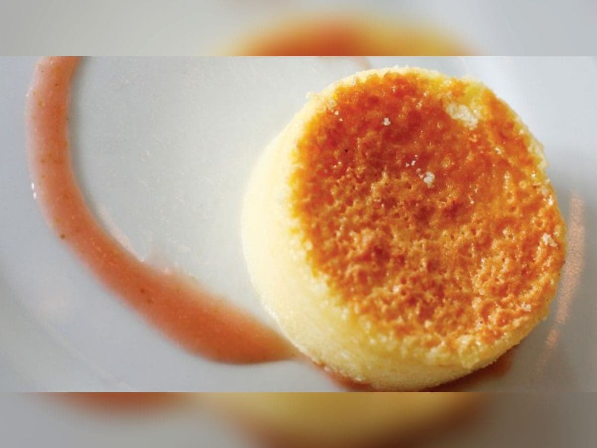Porción de torta de queso criollo dorada por encima, servida con un hilo de melado de papelón